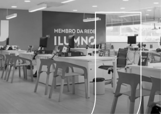 Fotografia da sala de atendimento Unijorge com mesas, cadeiras e computadores